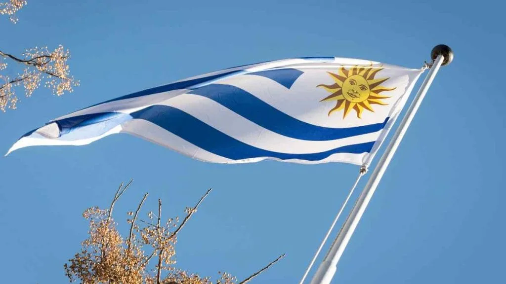 Bandeira do Uruguai tremulando no mastro, sob céu azul