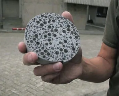 Mão segurando um disco de concreto poroso